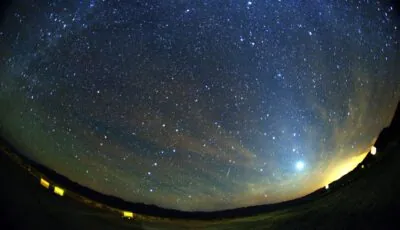 Trace lumineuse verte et rouge d’un météore des Orionides dans un ciel étoilé.